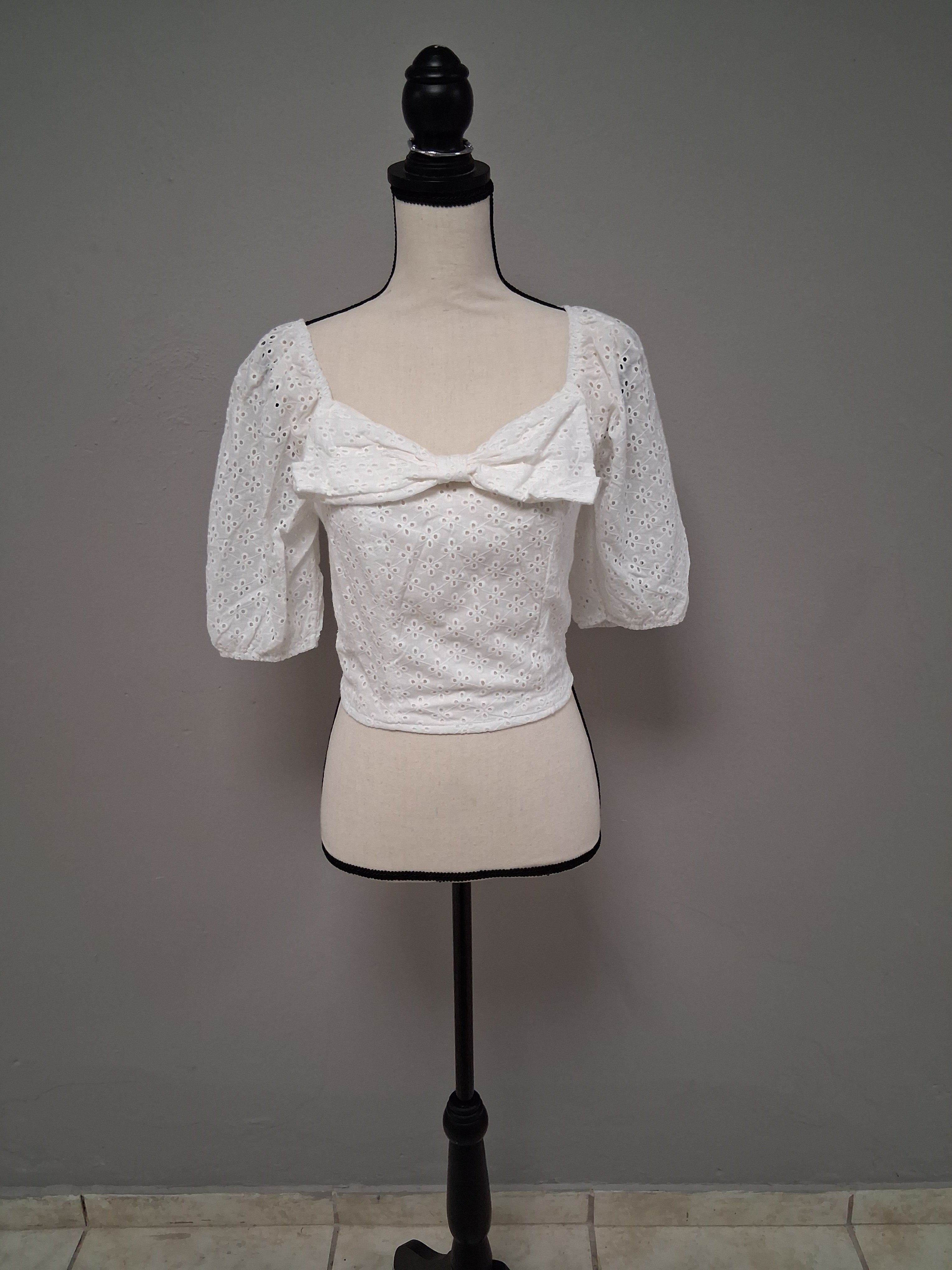 Blusa manga corta, con encaje y lazo en el pecho.